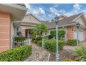 Beautiful villa with brick walkway, lush landscaping, mature palm, and attached garage at 2028 Lynx Run, North Port, FL 34288