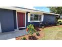 Inviting entryway with a red door, manicured landscaping, and a bright window at 2028 River Basin Ter, Punta Gorda, FL 33982