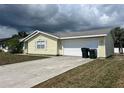 Side view of house featuring an attached garage, concrete driveway and easy access at 2696 Gisela Rd, North Port, FL 34287