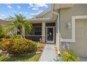 Charming home with screened porch, complemented by vibrant landscaping, offering a cozy and inviting entrance at 2747 Suncoast Lakes Blvd, Punta Gorda, FL 33980