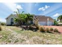 Charming single-story home with a three-car garage, well-maintained landscaping, and a red brick driveway at 5219 Guava Ter, Port Charlotte, FL 33981