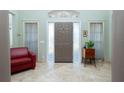 Inviting foyer with a neutral color scheme, tiled floors, and a solid wood front door with sidelights at 5219 Guava Ter, Port Charlotte, FL 33981