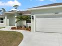 A tidy two-car garage with an extended driveway and vibrant landscaping that accents the curb appeal at 5353 Kaspar St, Port Charlotte, FL 33981