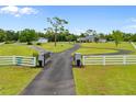 Long gated driveway leading to a beautiful home with a large front yard and lush landscaping, offering privacy at 5600 Blackjack S Ct, Punta Gorda, FL 33982