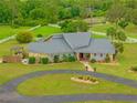 Charming home with stone accents, a circular driveway, and a lush green lawn, showcasing its inviting curb appeal at 5600 Blackjack S Ct, Punta Gorda, FL 33982