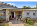 Inviting front porch with stone pillars and a cozy seating area, enhanced by lovely plants and decorative accents at 5600 Blackjack S Ct, Punta Gorda, FL 33982