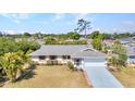 Well-maintained single-story home with manicured lawn and mature trees in a serene neighborhood at 566 Reading Nw St, Port Charlotte, FL 33952