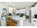 Bright kitchen with a breakfast bar, white cabinets, and an open layout that seamlessly connects to the adjacent dining area at 6103 Fabian Rd, North Port, FL 34287