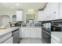 Well-lit kitchen featuring white cabinetry, modern appliances, and a functional layout, perfect for cooking and meal preparation at 6103 Fabian Rd, North Port, FL 34287