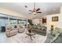 Spacious living room with plush seating, ceiling fan, and views of the outdoor pool and patio area at 7101 Dogwood Ct, North Port, FL 34287