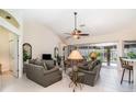 Comfortable living room with tile floors, ceiling fan, and sliding glass doors leading to an outdoor pool area at 7101 Dogwood Ct, North Port, FL 34287