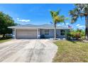 Single story home with a two car garage, concrete driveway and tropical landscaping at 7274 Alan Blvd, Punta Gorda, FL 33982