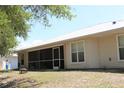 Backyard featuring a screened in patio with a grill, fire pit and view of the home's neutral siding and metal roof at 11422 2Nd Ave, Punta Gorda, FL 33955