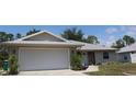 Charming single-Gathering home featuring a two-car garage, metal roof, and well-manicured front lawn at 11422 2Nd Ave, Punta Gorda, FL 33955
