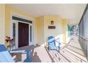 Inviting front porch with a dark wooden front door, comfortable seating, and attractive exterior lighting at 13204 Kakapo Ave, Port Charlotte, FL 33981