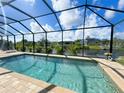 Screened-in pool offers a refreshing oasis with clear blue water and views of the serene canal at 13830 Begonia Cir, Port Charlotte, FL 33981