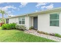 A quaint front entrance with a gray door and well-maintained landscaping invites you into this lovely home at 16965 Hawk Ct, Punta Gorda, FL 33982