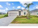 Charming single-Gathering home with a well-manicured lawn, lush landscaping, and a paved driveway at 17557 Santorini Ct, Venice, FL 34293