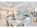 Spacious open-concept living area with dining and kitchen featuring seamless indoor-outdoor living with a large sliding door at 17557 Santorini Ct, Venice, FL 34293