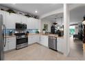 Kitchen showcasing stainless steel appliances, white cabinetry, granite counters, and a view of the dining area at 17857 Woodland Ct, Punta Gorda, FL 33982