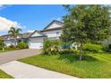 Landscaped front yard complements this stunning home with a brick driveway and a splash of tropical foliage at 19821 Montenero Way, Venice, FL 34293