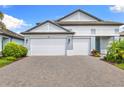Attractive home with a three-car garage, showcasing its appealing architecture and pristine driveway at 19821 Montenero Way, Venice, FL 34293