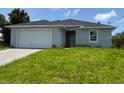 Charming single-story home featuring a two-car garage and a well-maintained lawn at 207 Baytree Dr, Rotonda West, FL 33947