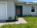 Inviting single-story home with a walkway leading to the entrance and a charming window at 207 Baytree Dr, Rotonda West, FL 33947