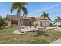 Desirable home with mature landscaping, a brick walkway, and an attached two-car garage at 219 Tait Se Ter, Port Charlotte, FL 33952