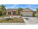 Beautiful single Gathering home with a well-maintained lawn and lush landscaping with a brick walkway at 219 Tait Se Ter, Port Charlotte, FL 33952