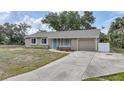 Single-story home with an attached garage, complemented by a paved driveway, walkway, and a neatly landscaped front yard at 23165 Glen Ave, Punta Gorda, FL 33980