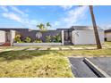 Front exterior of a home featuring decorative fencing, lush landscaping, and well-manicured grass at 232 W Henry St, Punta Gorda, FL 33950
