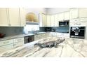 Modern kitchen boasts granite countertops, custom cabinets, and stainless steel appliances at 2399 Bendway Dr, Port Charlotte, FL 33948