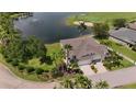 Aerial view of a beautifully landscaped home with a pond and golf course views at 24016 Buckingham Way, Punta Gorda, FL 33980