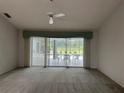 Spacious living room featuring a ceiling fan and sliding glass doors leading to the pool area at 3233 Meadow Run Dr, Venice, FL 34293