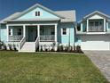 Beautiful light blue home with a covered front porch, white railings, and manicured lawn at 3548 Mondovi Ct, Punta Gorda, FL 33950