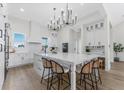 Modern kitchen featuring a large island with seating, stylish light fixtures, and stainless steel appliances at 3548 Mondovi Ct, Punta Gorda, FL 33950