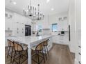 Bright kitchen with white cabinets, quartz countertops, large island with seating, and hardwood floors at 3548 Mondovi Ct, Punta Gorda, FL 33950
