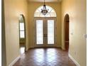 Bright foyer featuring tile flooring, arched doorways and chandelier hanging above double doors at 4150 Enclave Pl, Punta Gorda, FL 33980