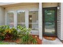 Close-up view of the townhome entrance featuring a storm door and mature landscaping at 4346 Rayfield Dr # 4346, Sarasota, FL 34243