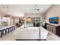 Bright, open-concept living room with a comfortable white sectional, tile flooring, and sliding glass doors to the pool at 523 Saint Girons Ct, Punta Gorda, FL 33950