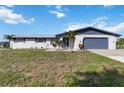 Charming single-story home with a well-kept lawn, nice landscaping, and a blue accent trim at 711 Forest Hill Nw Ln, Port Charlotte, FL 33948