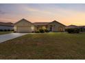 Charming single Gathering home with a well-manicured lawn and two-car garage at sunset at 7334 N Tulip Tree, Punta Gorda, FL 33955