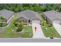 An aerial view of the house with a well maintained lawn and mature landscaping, and a two car driveway at 7652 Mikasa Dr, Punta Gorda, FL 33950