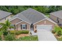 A front elevation of the home with a well-manicured lawn, shrubs, and a two car garage at 7652 Mikasa Dr, Punta Gorda, FL 33950