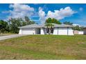 Charming single-story home featuring a two-car garage, and tropical landscaping in a well-maintained lawn at 891 Bayard St, Port Charlotte, FL 33948