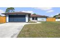 Beautiful one story home with a blue garage door and manicured lawn at 1041 S Salford Blvd, North Port, FL 34287