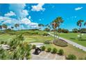 Scenic golf course view with manicured greens, palm trees, and a golf cart at 1062 Eagles Flight Way, North Port, FL 34287