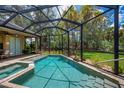 Inviting screened-in pool and spa with lush landscape for privacy and relaxation at 1062 Eagles Flight Way, North Port, FL 34287
