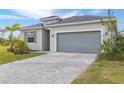 A well-manicured lawn and a stone driveway lead up to the garage of this single Gathering home at 11088 Pinot Dr, Venice, FL 34293